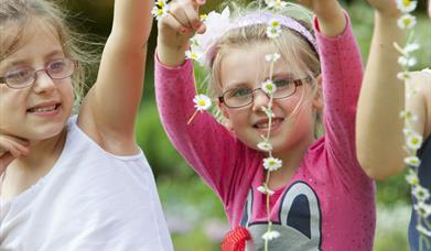 Children with daisy chains in the gardens at Knightshayes, Devon.
